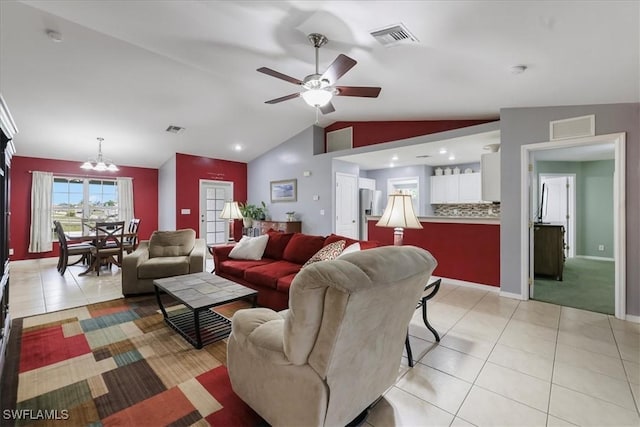 tiled living room featuring lofted ceiling and ceiling fan with notable chandelier