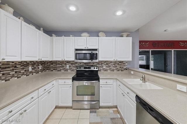 kitchen featuring sink, light tile patterned floors, stainless steel appliances, and white cabinets