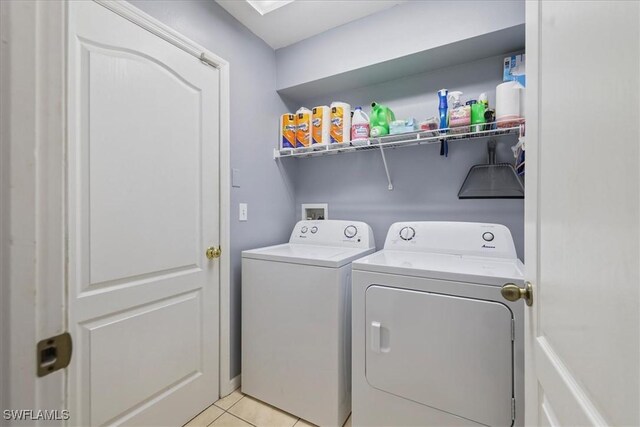 clothes washing area featuring light tile patterned flooring and independent washer and dryer