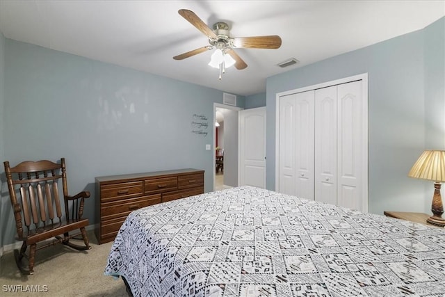 carpeted bedroom with ceiling fan and a closet