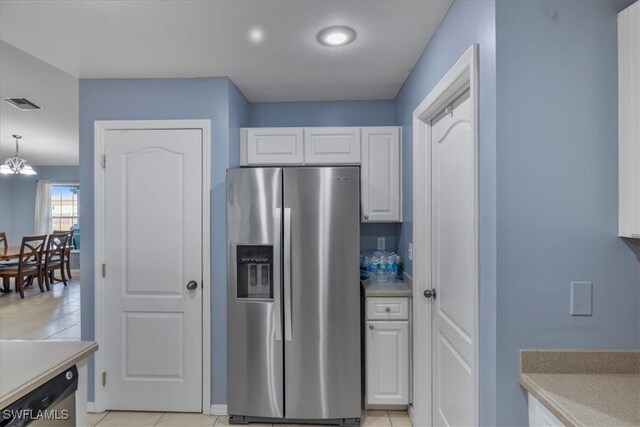 kitchen with light tile patterned floors, appliances with stainless steel finishes, white cabinetry, a notable chandelier, and decorative light fixtures