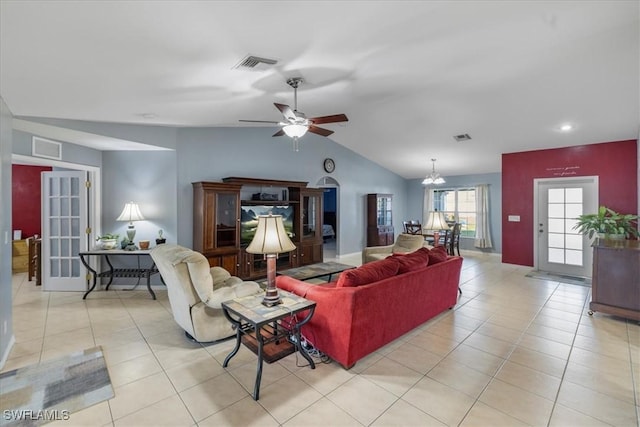 tiled living room featuring lofted ceiling and ceiling fan with notable chandelier