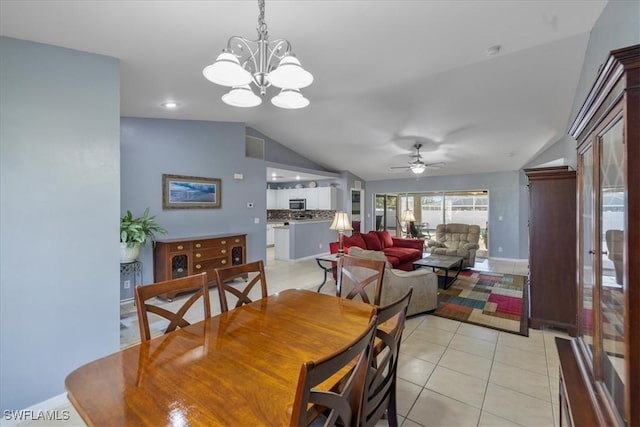 tiled dining room featuring lofted ceiling and ceiling fan with notable chandelier