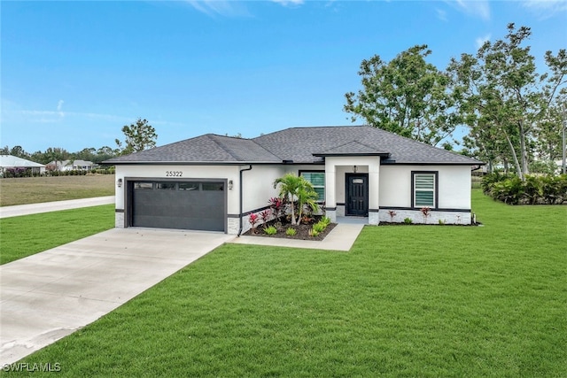 prairie-style home featuring a garage and a front lawn