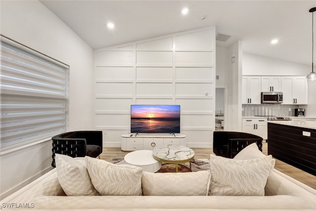 living room with vaulted ceiling and light hardwood / wood-style floors