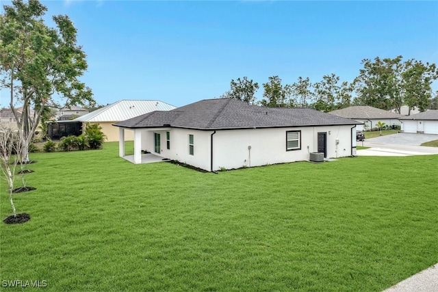 back of house featuring a yard and central AC unit