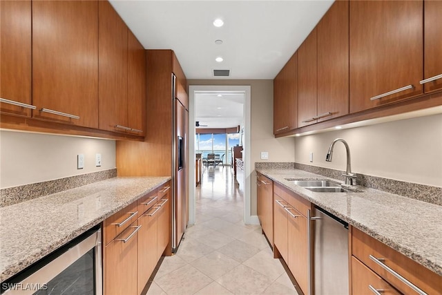 kitchen with sink, stainless steel dishwasher, wine cooler, and light stone counters