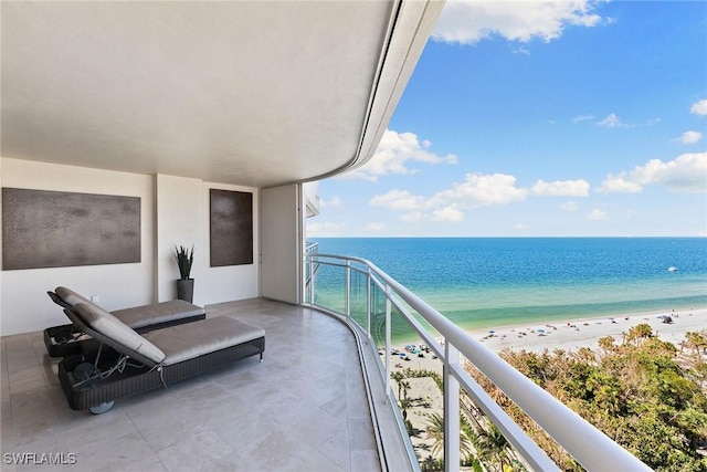 balcony featuring a view of the beach and a water view