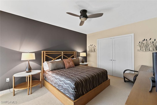 bedroom with ceiling fan, a closet, and light carpet