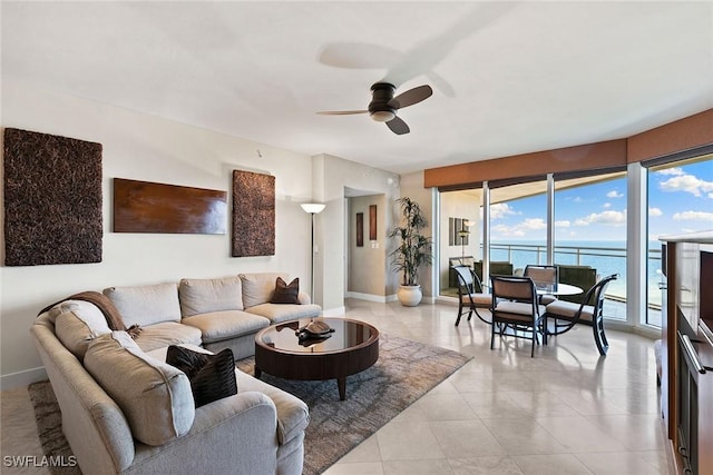 tiled living room with a water view and ceiling fan