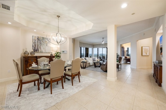 tiled dining room featuring ornamental molding, a raised ceiling, and a chandelier