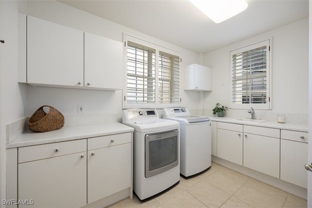 laundry room featuring washer and dryer, sink, light tile patterned floors, and cabinets