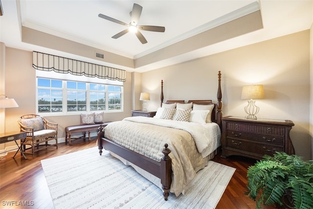 bedroom featuring crown molding, a raised ceiling, ceiling fan, and hardwood / wood-style flooring