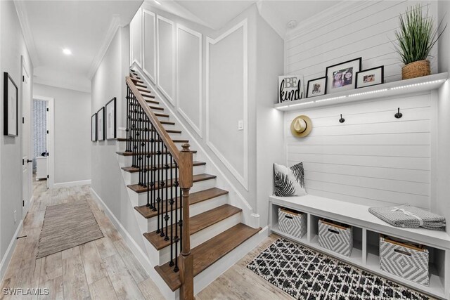 mudroom with crown molding and light hardwood / wood-style floors