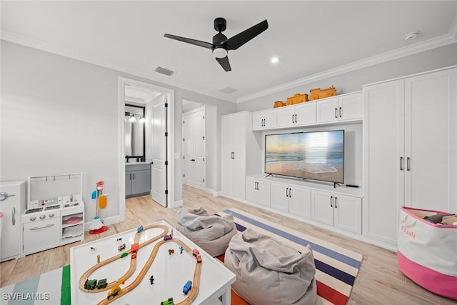 rec room with ceiling fan, light wood-style flooring, visible vents, and crown molding