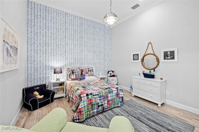 bedroom featuring light hardwood / wood-style flooring and a high ceiling