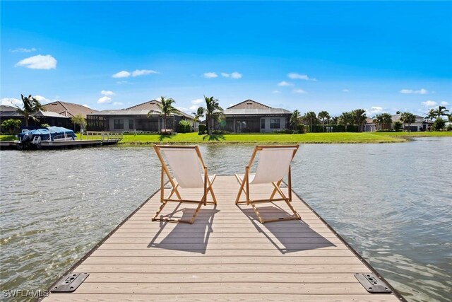 view of dock with a water view and a yard