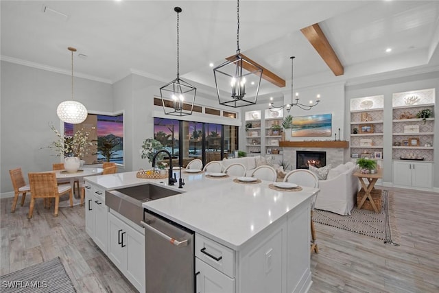 kitchen featuring light wood-style floors, white cabinets, a sink, and stainless steel dishwasher