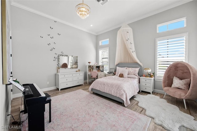 bedroom with visible vents, an inviting chandelier, ornamental molding, wood finished floors, and baseboards