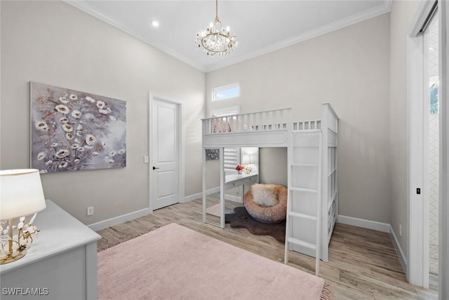 bedroom with a chandelier, crown molding, baseboards, and wood finished floors