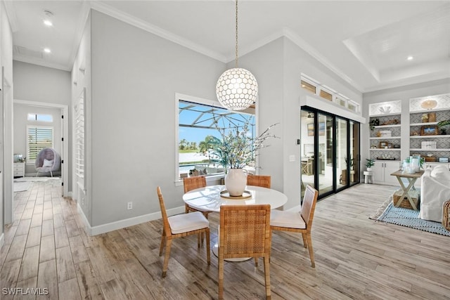 dining space featuring crown molding, recessed lighting, a high ceiling, light wood-style floors, and baseboards