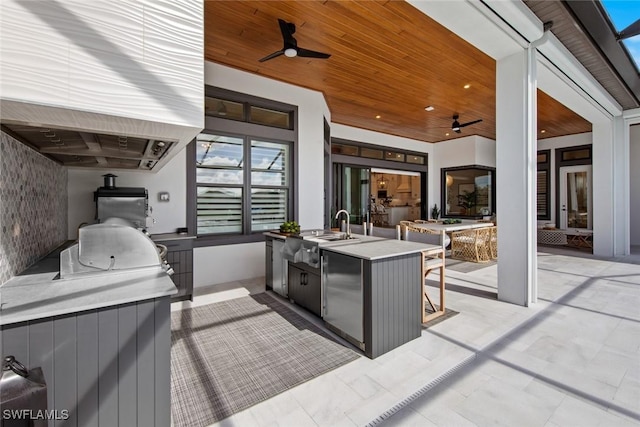 view of patio / terrace with an outdoor kitchen, sink, and ceiling fan