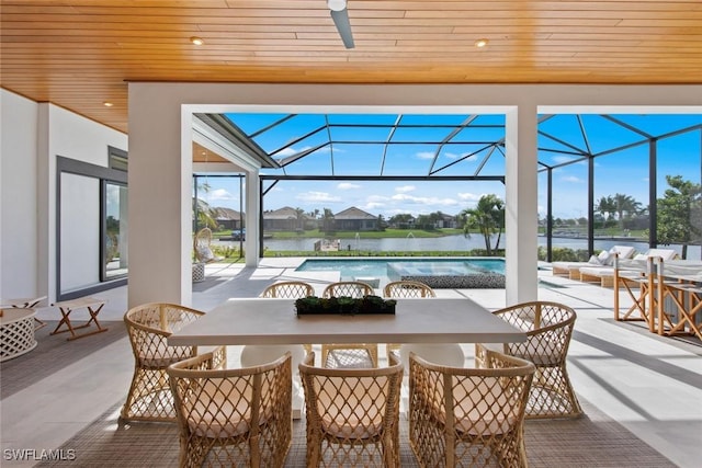 view of patio with an outdoor pool, glass enclosure, ceiling fan, a water view, and outdoor dining space