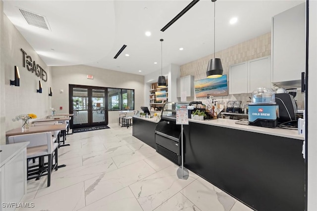 kitchen featuring hanging light fixtures, decorative backsplash, french doors, and white cabinets