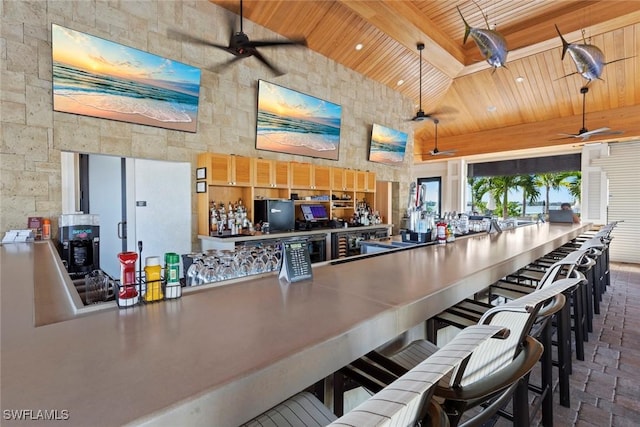 kitchen featuring wood ceiling, a high ceiling, a ceiling fan, and beam ceiling