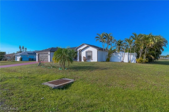 view of front of home with a garage and a front lawn