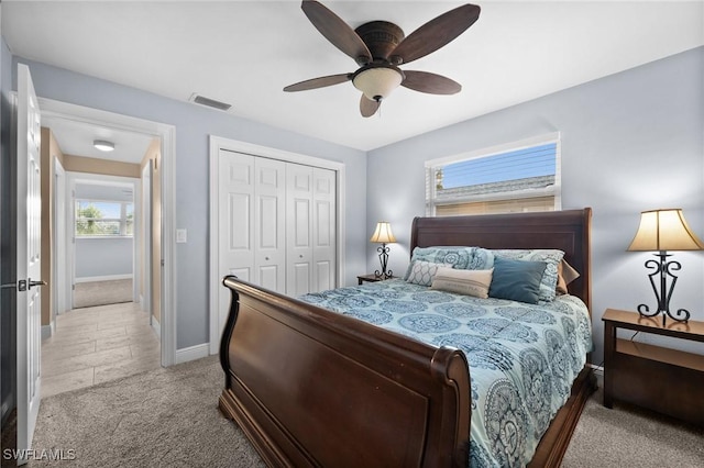 carpeted bedroom with ceiling fan and a closet