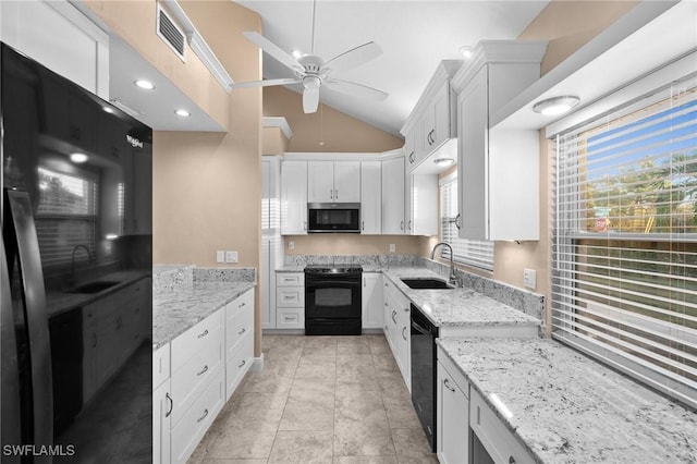 kitchen featuring light stone counters, white cabinets, sink, and black appliances