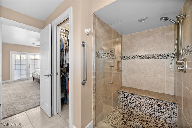 bathroom featuring ceiling fan, tile patterned floors, and tiled shower