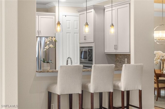 kitchen featuring white cabinets, a breakfast bar area, and stainless steel appliances