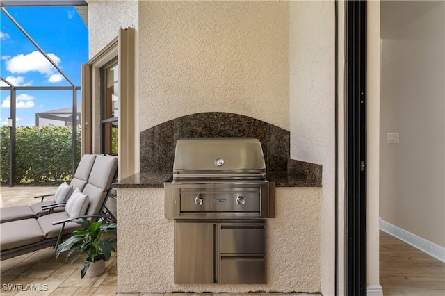 view of patio with exterior kitchen and a grill