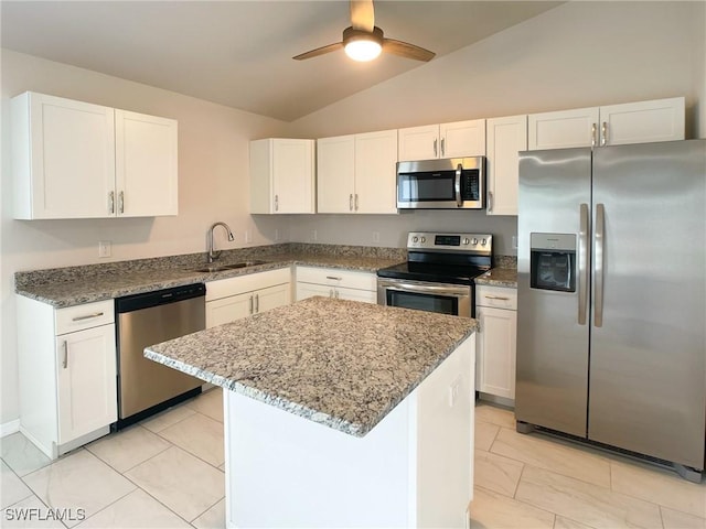 kitchen with white cabinets, a center island, stainless steel appliances, sink, and vaulted ceiling