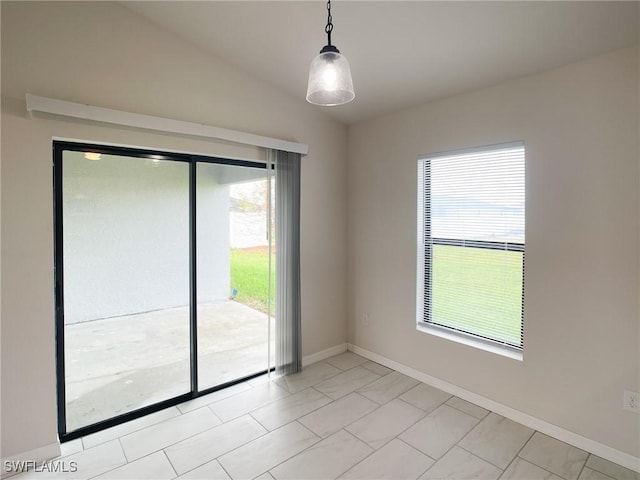 tiled empty room featuring lofted ceiling