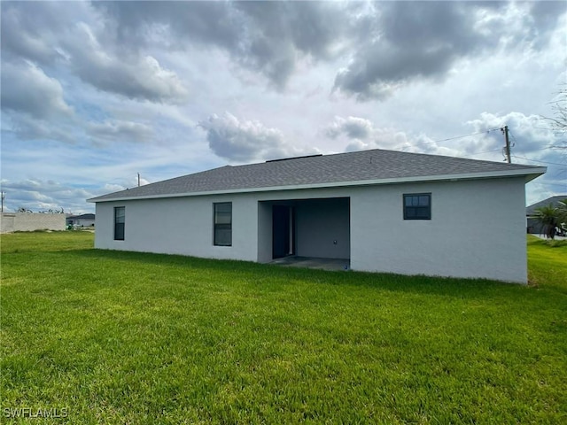 rear view of house featuring a yard