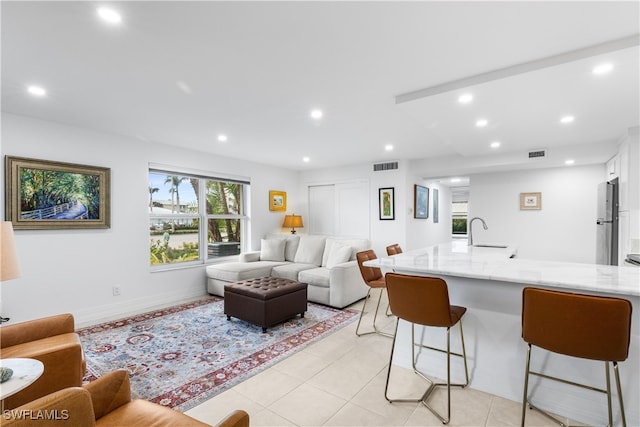 living room featuring sink and light tile patterned floors