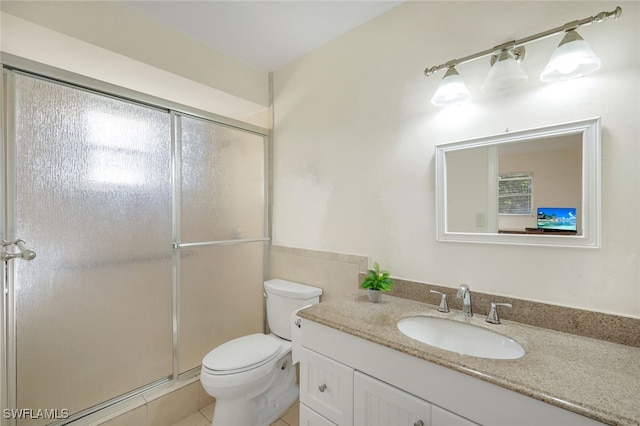 bathroom featuring vanity, toilet, and a shower with door