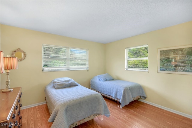 bedroom featuring multiple windows and light hardwood / wood-style flooring