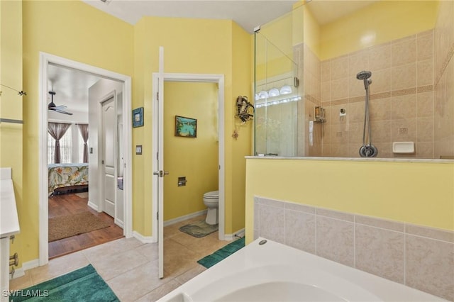 bathroom featuring independent shower and bath, tile patterned floors, ceiling fan, and toilet