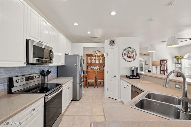 kitchen featuring light tile patterned flooring, sink, hanging light fixtures, stainless steel appliances, and white cabinets