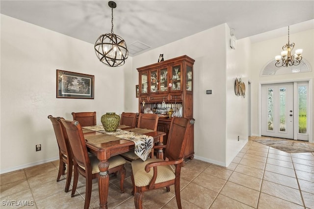 dining room with light tile patterned floors and a notable chandelier