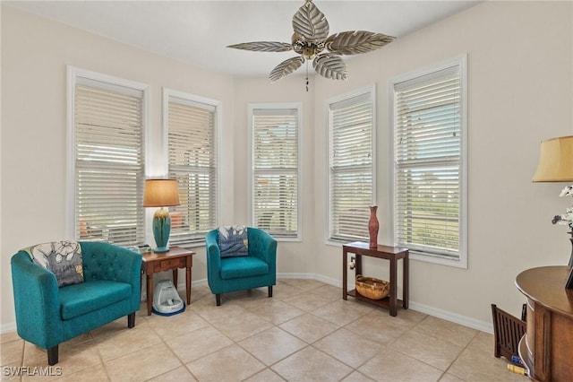 sitting room featuring a wealth of natural light, light tile patterned floors, and ceiling fan