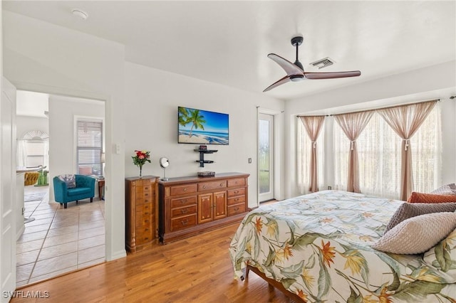 bedroom featuring access to outside, light hardwood / wood-style floors, and ceiling fan