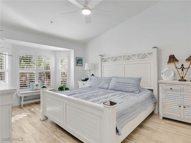 bedroom with ceiling fan, light hardwood / wood-style floors, and lofted ceiling