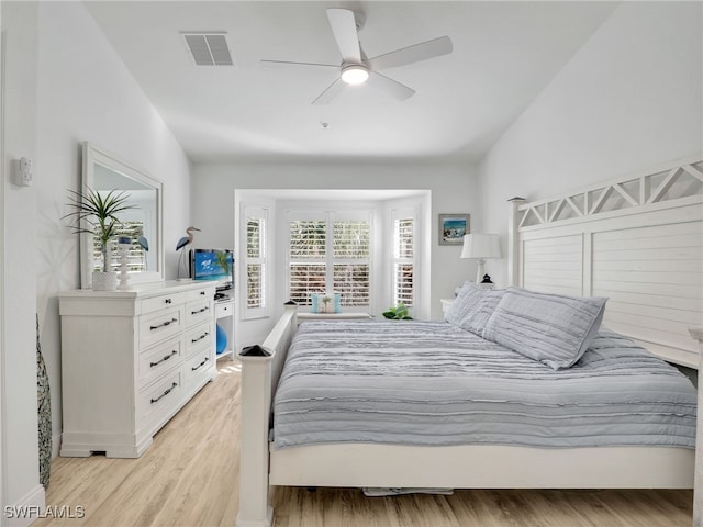 bedroom with ceiling fan, light wood-type flooring, and vaulted ceiling