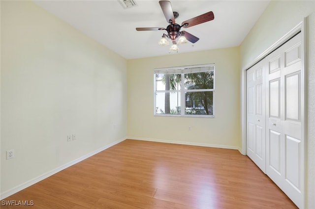 unfurnished bedroom with light hardwood / wood-style floors, ceiling fan, and a closet