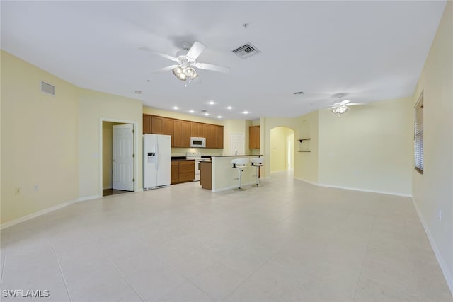 unfurnished living room with light tile patterned flooring and ceiling fan